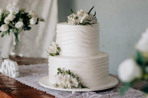 Free photo of gateau de mariage blanc elegant a deux etages avec fleurs